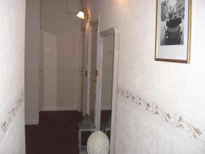 a hallway with a staircase with a mirror and a picture on the wall at La Marjolaine in Juan-les-Pins