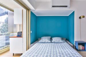 カンヌにあるStudio Cosy Pradignacのベッドルーム1室(青い壁、枕付きのベッド1台付)