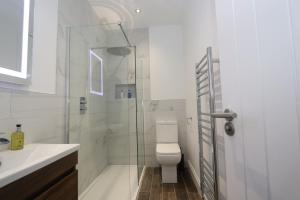 Dollar Apartments-39 Bridge Street في دولار: حمام مع مرحاض ودش زجاجي +27 صورة