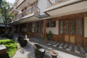 a courtyard of a building with chairs and a checkered floor at Hotel Loreto in Santiago