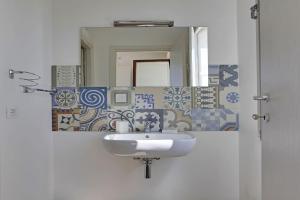 een badkamer met een wastafel en een spiegel bij Casa Vacanze Senia Del Rais in Favignana