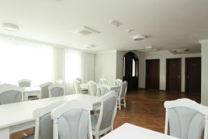 uma sala vazia com mesas brancas e cadeiras brancas em Pensiunea Hanna em Baile Felix