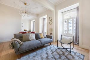 una sala de estar con un sofá y una silla en Cosy Marques de Pombal Apartment, en Lisboa