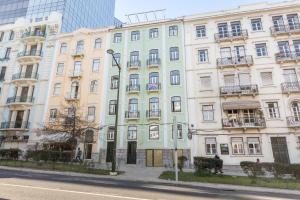 Un gran edificio blanco al costado de una calle. en Cosy Marques de Pombal Apartment, en Lisboa