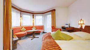 pokój hotelowy z łóżkiem i kanapą w obiekcie Beurener Hof w mieście Beuren