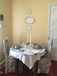 a dining room table with plates and candles on it at Magnolia Cottage Bed and Breakfast in Natchez