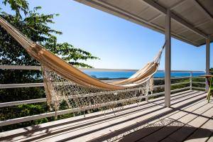 a hammock on a deck overlooking the ocean at Funky Monkey Lodge in Santa Teresa Beach