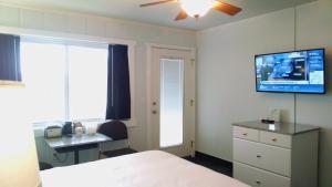 a bedroom with a bed and a desk and a tv at Murray Inn and Art Gallery in Murray +23 photos