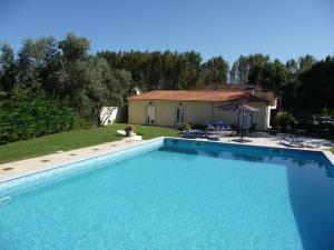 a large swimming pool in a yard with a house at Casa Águas Mansas in Cadima