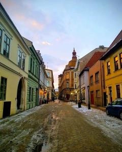 an old street in a city with snow on the ground at Old Town Apartment Podtatranskeho in Košice