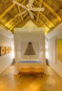 a bedroom with a bed with a ceiling fan at Mi Otra Casa in Sayulita +189 photos