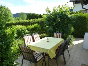 einem Tisch mit vier Stühlen und einem gelben Tischtuch in der Unterkunft Landhaus Monika in Bodensdorf