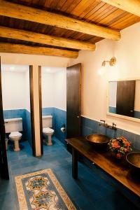a bathroom with two sinks and two toilets at Hotel Refugio Pozo Azul in Aquitania