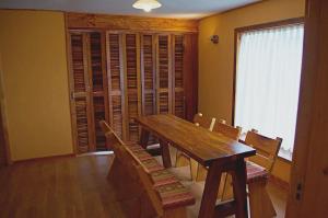 a dining room with a wooden table and chairs at Apart Hotel Claro de Luna in Frutillar