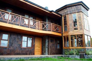 a large wooden house with a balcony on it at Apart Hotel Claro de Luna in Frutillar