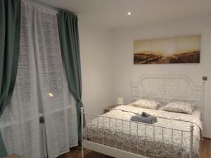 a bedroom with a white bed and green curtains at Modern&Cozy Rooms in Poznań
