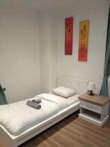 a bed in a room with two paintings on the wall at Modern&Cozy Rooms in Poznań