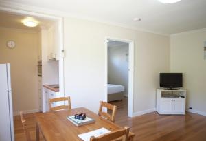 a living room with a dining room table and a television at City Centre Motel in Bendigo