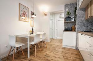 a kitchen with a white table and chairs in a room at L&L Leisure Apartments Plitvice in Plitvička Jezera