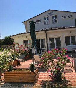 a building with a umbrella and some plants and flowers at PENZION ANIKO GOLD *** in Horné Saliby