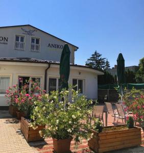 a group of chairs and flowers in front of a building at PENZION ANIKO GOLD *** in Horné Saliby