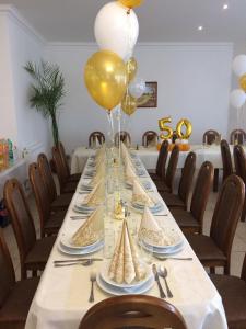 a long table with plates and balloons on it at PENZION ANIKO GOLD *** in Horné Saliby +7 photos
