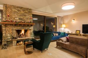 a living room with a fireplace and a couch at Luxury Chalet & Spa Tia Maria in Bansko