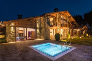 a house with a swimming pool in front of a building at Luxury Chalet & Spa Tia Maria in Bansko