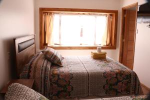 a bedroom with a bed with a window at Hostal Luna del Mar 840-B in La Serena