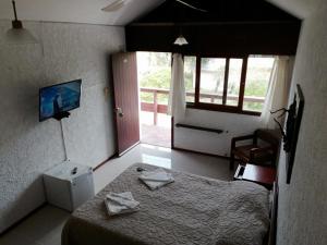 Un dormitorio con una cama y un televisor y una ventana. en Hotel Yeruti, en La Paloma