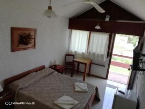 Un dormitorio con una cama y una mesa y una ventana. en Hotel Yeruti, en La Paloma