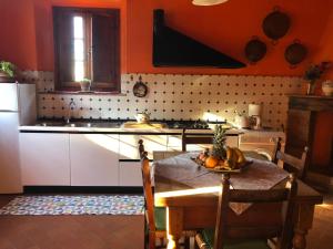 een keuken met oranje muren en een tafel met een ananas erop bij Podere Casato in Montespertoli