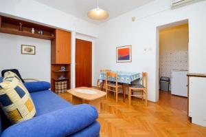 ノヴァリャにあるApartment and Rooms Biserkaのリビングルーム(青いソファ、テーブル付)