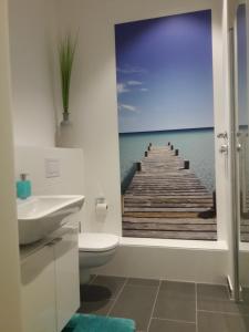 a bathroom with a pier painting on the wall at Top-Apartment a.d. Messe in Munich