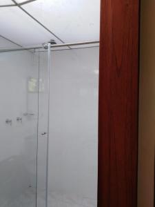 a bathroom with a shower with a glass door at Hosteria Campestre San Fermin in Ráquira