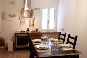 une cuisine avec une table en bois et des chaises ainsi qu'une salle à manger dans l'établissement Al Piano - home away from home, à Venise