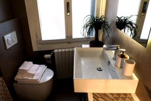 La salle de bains est pourvue d'un lavabo, de toilettes et d'un miroir. dans l'établissement Al Piano - home away from home, à Venise