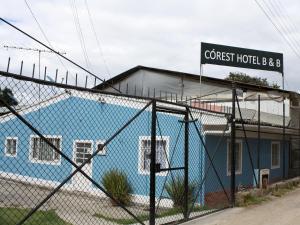 Córest Hotel B&B في Tocancipá: مبنى بلو مع علامة على قمة السياج
