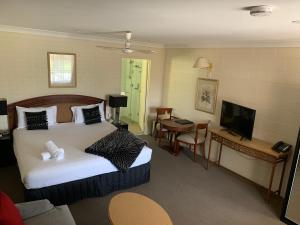 una camera d'albergo con letto e TV di Picton Valley Motel Australia a Picton