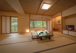 uma grande sala de estar com mesa e cadeiras em Iizaka Onsen Surikamitei Ohtori em Fukushima