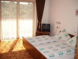 A bed or beds in a room at Hotel Weinhaus Liesertal