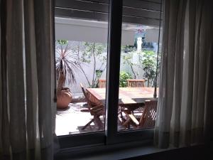 uma vista para uma mesa e cadeiras a partir de uma janela em Palermo 3 Habitaciones privadas em Buenos Aires