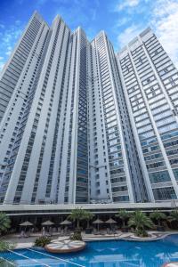 un gran edificio con una piscina frente a él en The Alpha Suites en Manila