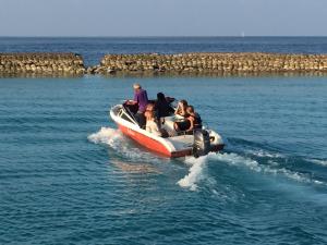 un grupo de personas en un barco en el agua en Noomuraka Inn, en Omadhoo
