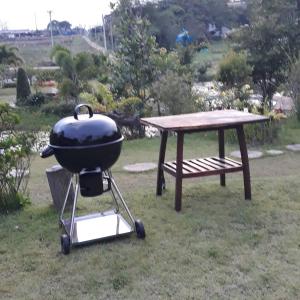 a grill and a picnic table in the grass at Korp View House in Wang Nam Khieo