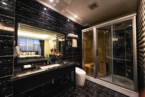a black bathroom with a sink and a shower at Tuong Vi Hotel Saigon in Ho Chi Minh City