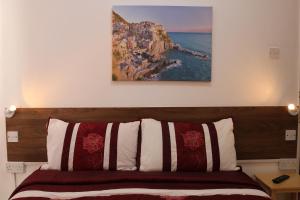 um quarto com uma cama com um quadro na parede em Anand Lodge em Royal Tunbridge Wells
