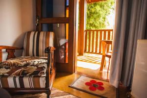 a room with a chair and an open door at Pousada Refugio dos Palmares in São Bento do Sapucaí