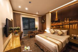 a hotel room with a bed and a picture of the eiffel tower at Tuong Vi Hotel Saigon in Ho Chi Minh City