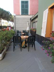 um pátio com quatro cadeiras e uma mesa e um edifício em Hotel Italia em Moneglia